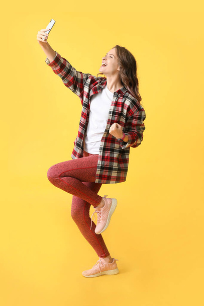 Heureuse jeune femme prenant selfie sur fond de couleur
 - Photo, image