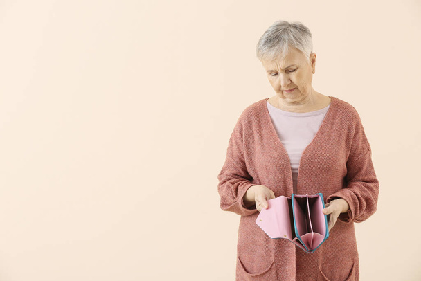 Femme âgée avec portefeuille vide sur fond de couleur
 - Photo, image