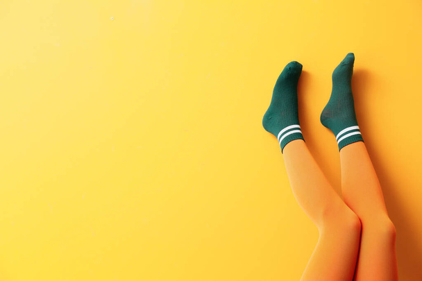 Las piernas de la mujer joven en calcetines y medias en el fondo de color
 - Foto, Imagen