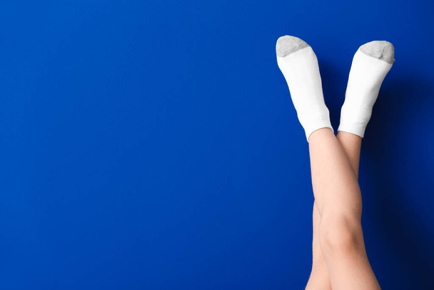 Beine von kleinen Mädchen in Socken auf farbigem Hintergrund - Foto, Bild