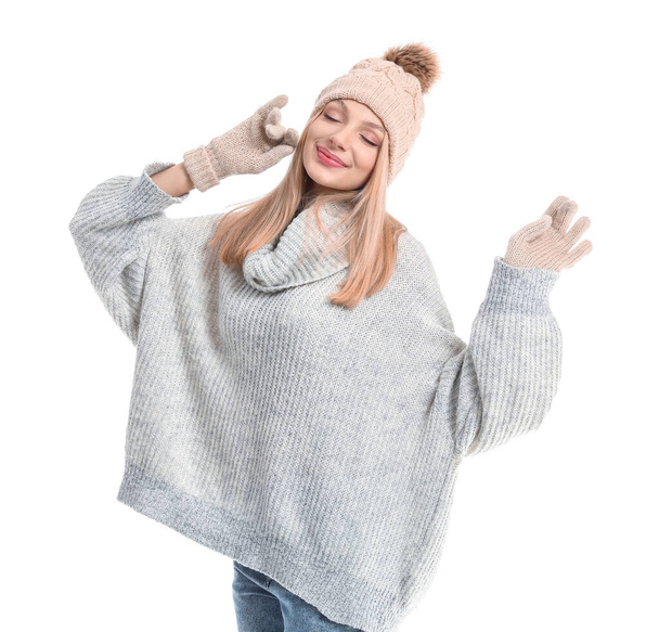 Mujer joven en jersey cálido, sombrero y guantes sobre fondo blanco
 - Foto, Imagen