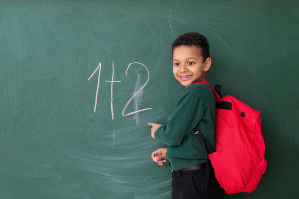 Cute African-American schoolboy near blackboard in classroom - Photo, Image