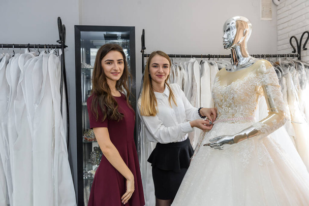 Bride in wedding shop with tailor and wedding dress - Photo, Image