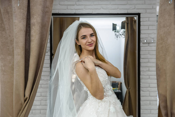 Jeune mariée blonde en robe de mariée posant pour caméra
 - Photo, image