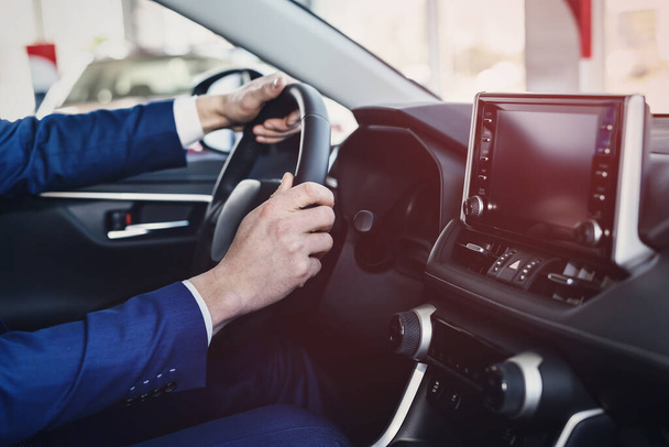 Manos masculinas en el volante, interior del coche
 - Foto, imagen
