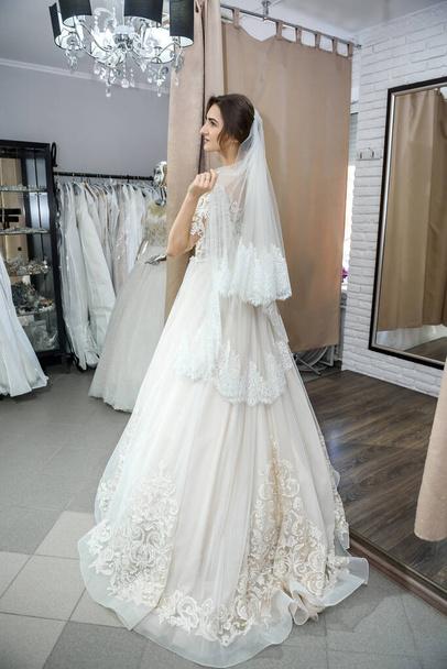 Portrait of young bride in wedding dress in shop - Photo, Image