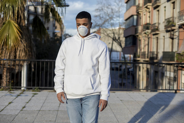 Sick man wearing protective facial mask against transmissible infectious diseases and as protection against the coronavirus in public place. - Foto, afbeelding