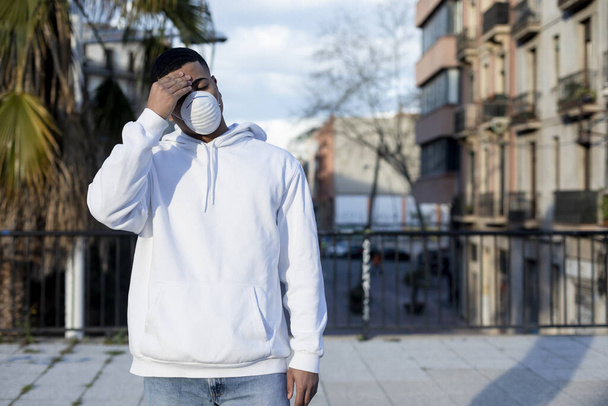 Sick man wearing protective facial mask against transmissible infectious diseases and as protection against the coronavirus in public place. - Photo, Image