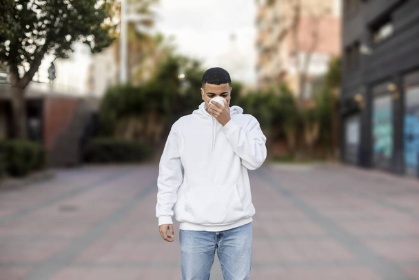 Sick man wearing protective facial mask against transmissible infectious diseases and as protection against the coronavirus in public place. - 写真・画像