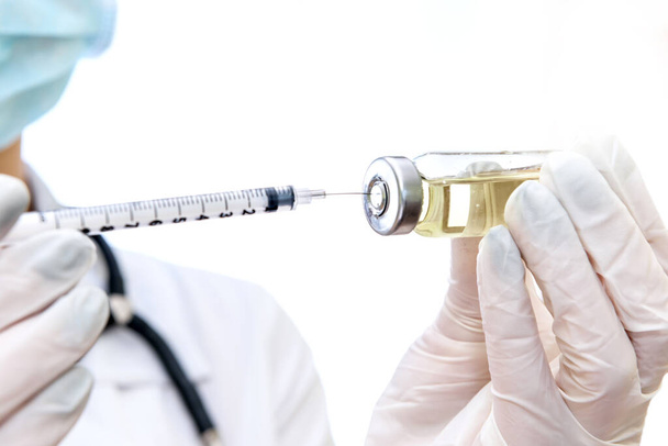 Médico tomando medicação líquida da ampola para a seringa
 - Foto, Imagem