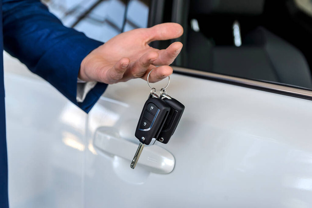 Dealer holding keys from new car close up - Foto, imagen