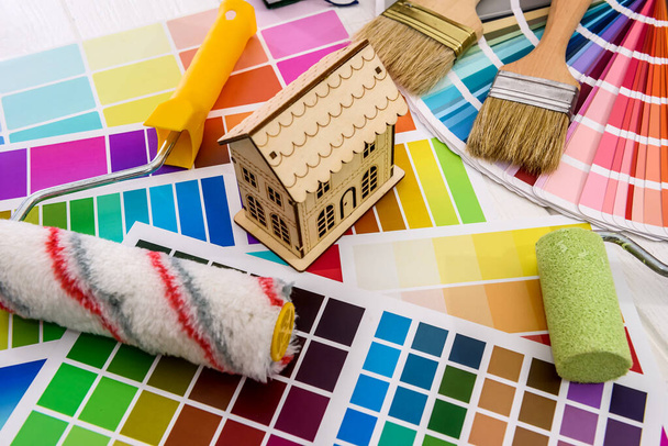 Modelo de casa de madeira e rolo na paleta de cores
 - Foto, Imagem
