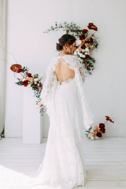  Decor of the ceremony with red roses. Portrait of the bride in the style of fine art. Wedding lace dress on the girl. - Valokuva, kuva
