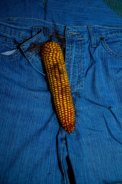 Кукурудза і стрічка вимірюють, як пеніс на фоні джинсів
 - Фото, зображення
