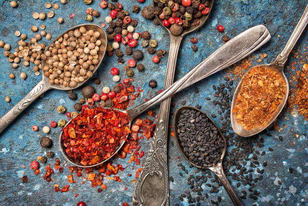 Top view of mix bright spices in vintage silver spoon as ingredient for healthy food on blue concrete background - Φωτογραφία, εικόνα