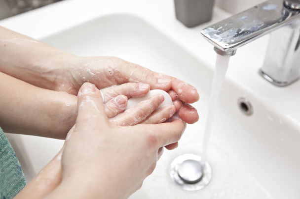 Mother helps her son to wash his hands with soap - Valokuva, kuva