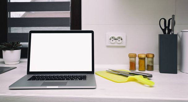 Moderní laptop na dřevěném stole v kuchyni. Koncepce hledání recepty, objednávání ingrediencí a surfování na webu - Fotografie, Obrázek