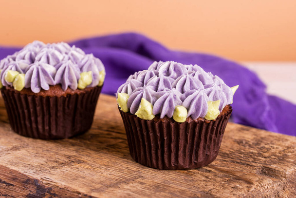 Schokoladen-Cupcakes auf einem Holztisch mit gesalzenem Karamell im Inneren. Dessert, Essen - Foto, Bild