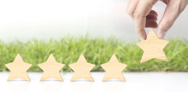 手の形をした木製の5つ星。最高のビジネスサービス評価顧客体験のコンセプト - 写真・画像