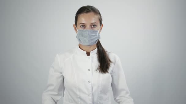 Doctor in medicine mask put on a stethoscope - Filmati, video