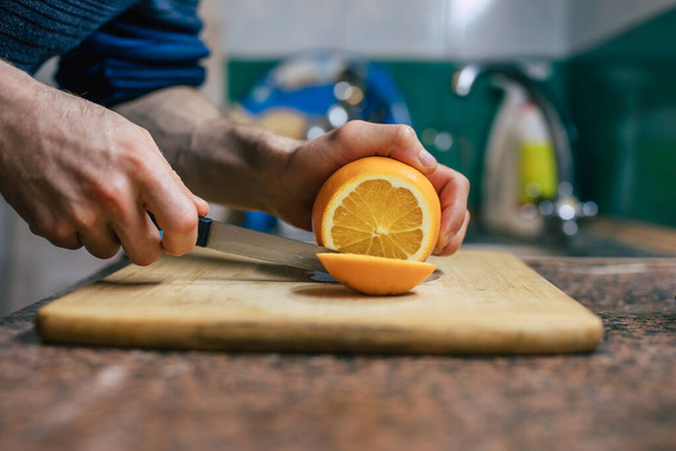 Close Up Of Mans Hands Cutting Orange - Fotó, kép