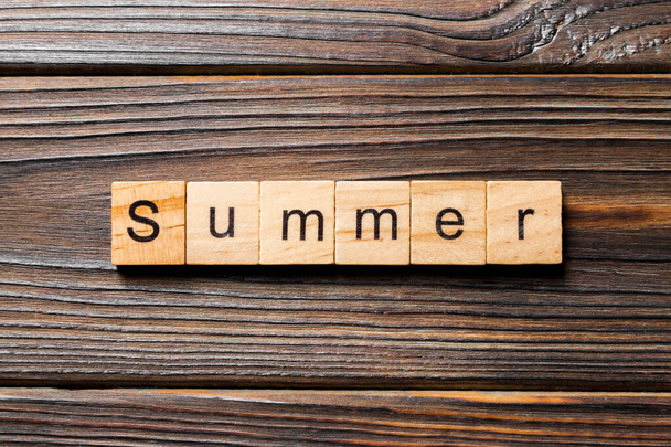 Sommerwort auf Holzblock geschrieben. Sommertext auf Holztisch für Ihre Gestaltung, Konzept. - Foto, Bild