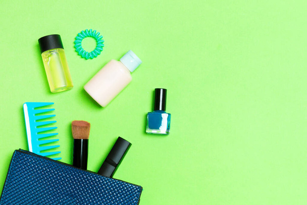 Maquillage produits débordant de sac cosmétique sur fond vert avec espace vide pour votre design
. - Photo, image
