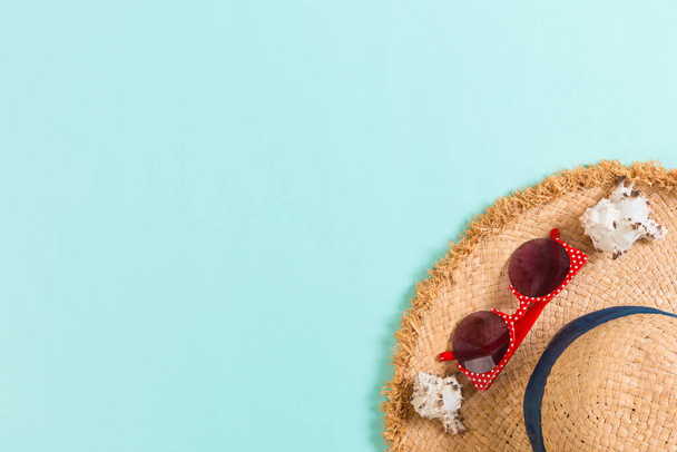 Sommerurlaub Hintergrund mit Strohhut und Muscheln auf blauem Hintergrund Draufsicht mit Kopierraum. - Foto, Bild
