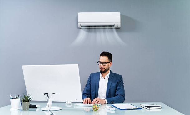 Businessman Enjoying The Cooling Of Air Conditioner In The Office - Foto, Bild