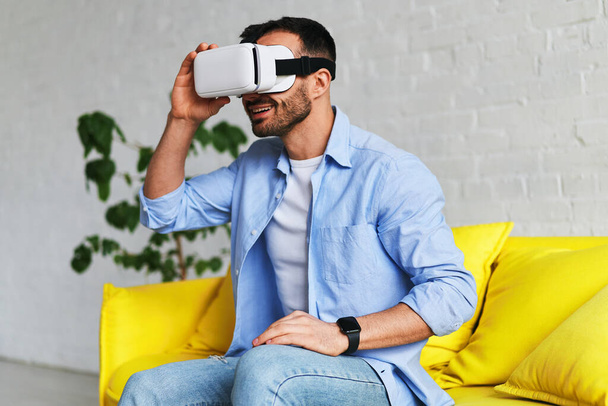 Homme excité dans des lunettes de réalité virtuelle souriant tout en ayant l'expérience VR
 - Photo, image