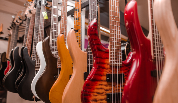 Primo piano di chitarre elettriche di fila in un enorme negozio di strumenti, concetto strumentale musicale
 - Foto, immagini