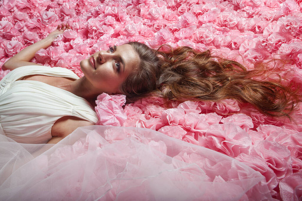 Beautiful female in white wedding dress in pink paper flowers - Fotoğraf, Görsel