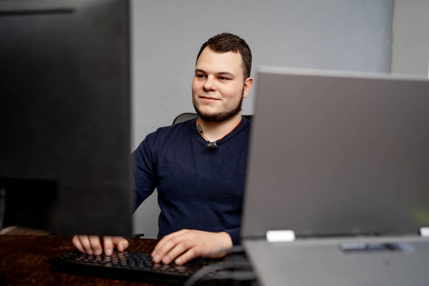 Male programmer working on desktop computer near monitor at office in software development company. Website design programming and coding technologies. - Fotó, kép
