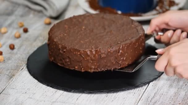 Konditor legt Schokoladenmoussekuchen auf eine Schieferplatte. Süßspeisen. - Filmmaterial, Video