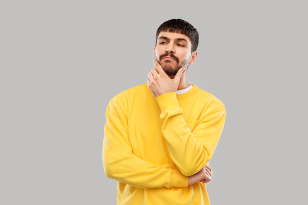 thinking young man in yellow sweatshirt - Foto, Imagem