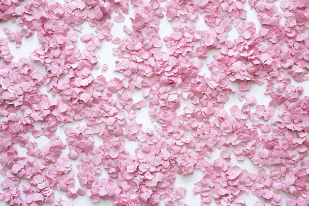 Abstract decor met roze confetti op witte achtergrond. Zicht van bovenaf. Plat gelegd. Kopieerruimte. - Foto, afbeelding