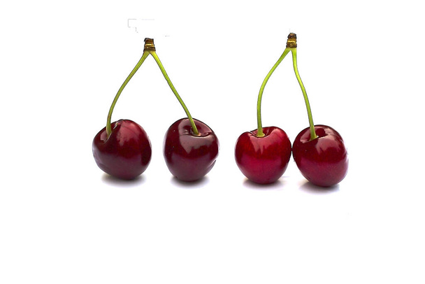 Cherry isolated on white with clipping path. Four cherries with stems. Ripe cherry isolated. Sherry berry fruit isolated on white background. Sweet cherry. Red cherry. - Fotó, kép