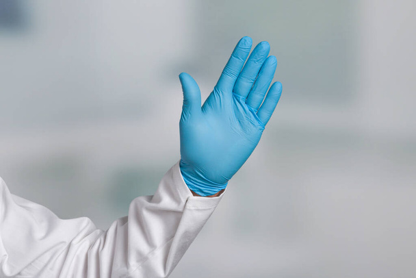 Το χέρι του γιατρού σε ιατρικά γάντια δείχνει στάση, καμία είσοδος στη ζώνη καραντίνας - Φωτογραφία, εικόνα