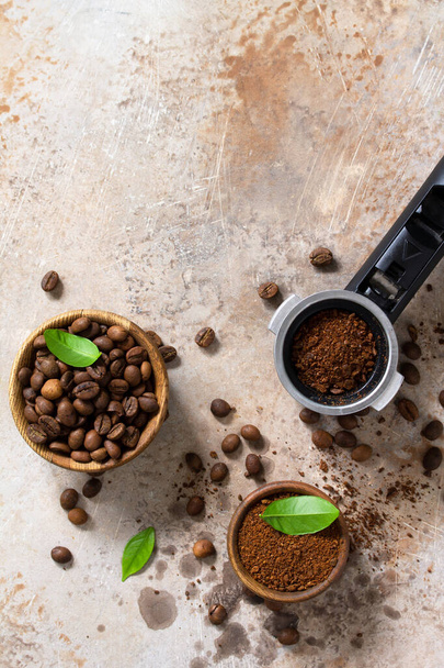 Ingrediënten voor een koffiezetapparaat. Koffiebonen en gemalen poeder op een stenen aanrecht. Bovenaanzicht platte achtergrond. Kopieerruimte - Foto, afbeelding