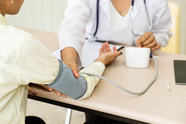 Lekarz medycyny dać konsultacji do ciśnienia krwi pacjenta i środek - Zdjęcie, obraz