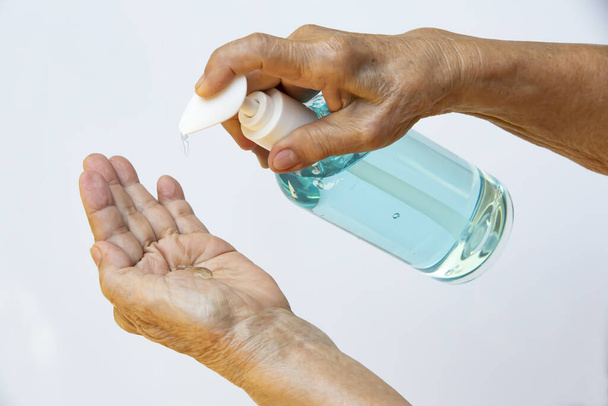 As mãos da senhora estão pressionando uma garrafa de dispensador de bomba de gel desinfetante para lavar as mãos. Close up & Macro shot, Foco seletivo, Prevenção de covid19, Bactérias, conceito de saúde, 7 passo lavar a mão
 - Foto, Imagem