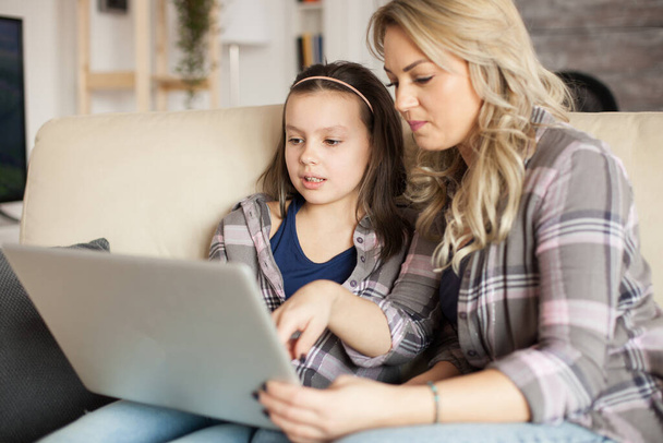 Anya és lánya használja laptop vezeték nélküli technológiával - Fotó, kép