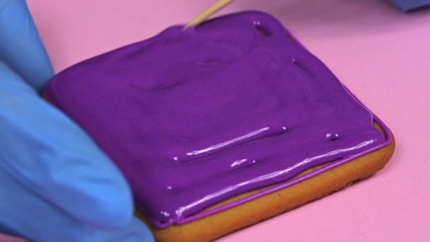 Aplicación de esmalte violeta a galletas de jengibre, primer plano
 - Metraje, vídeo