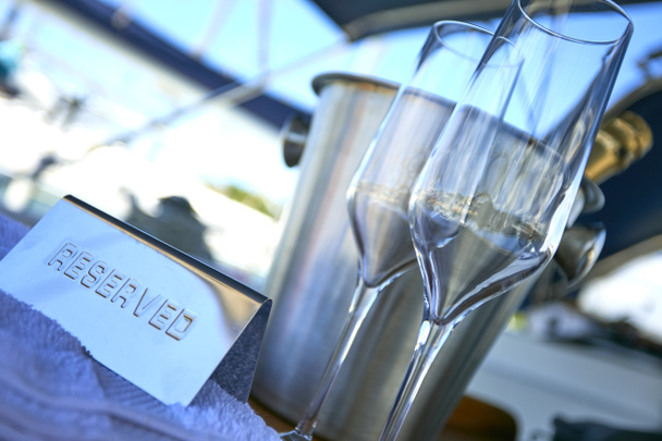 Soirée romantique de luxe sur yacht de croisière avec cadre champagne. Verres vides et bouteille de champagne et coucher de soleil tropical avec fond marin
 - Photo, image