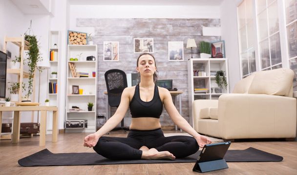 Mujer joven en un estado mental pacífico mientras hace yoga
 - Foto, Imagen