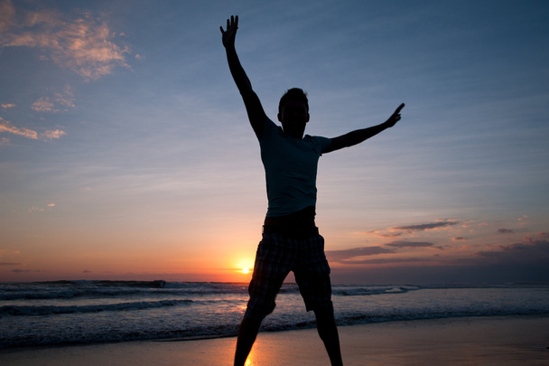 Man jumping on the beach at sunset - Foto, Bild