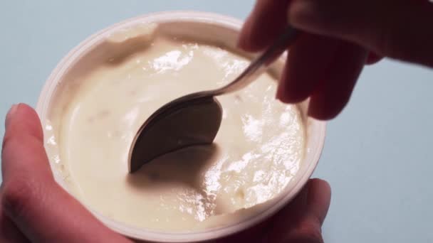 Woman eating gluten free yogurt with a spoon. Female hands pick up a cottage cheese with a spoon, isolated on a white background - Imágenes, Vídeo