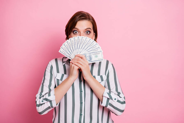Portrait of amazed shocked girl hide cover her face with money fan she get from deposit credit bank wear modern clothing isolated over pink color background - Foto, Imagem