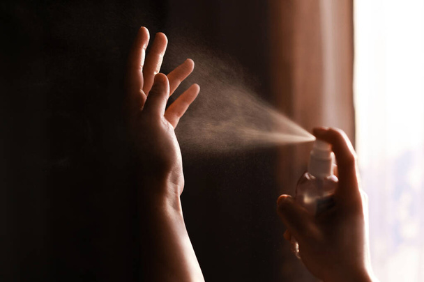 Desinfectar as mãos. Pessoa em uso de spray anti-séptico nas mãos para prevenção de gripe ou coronavírus. Higiene pessoal. Como limpar as mãos direito
 - Foto, Imagem