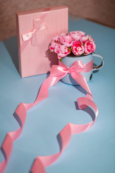 Composition flat lay of beautiful roses in a matal cup and pink gift box. Greeting for Birthday, Women or Mothers Day. - Foto, imagen